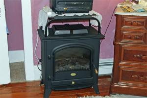 a black stove with a fireplace in a room at Belle Aire Mansion Guest House in Galena