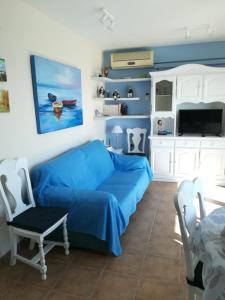 a living room with a blue couch and a tv at apartamento junto al mar in Cullera