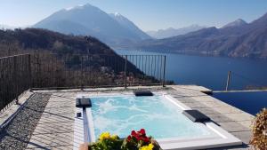 een zwembad met uitzicht op een meer en de bergen bij Villa Silvi piscina sauna e hot tub in Perledo