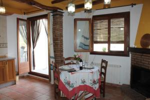 a dining room with a table and chairs and a fireplace at Suite Castillejo in Capileira