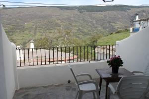 a balcony with a table and chairs and a view at Suite Castillejo in Capileira