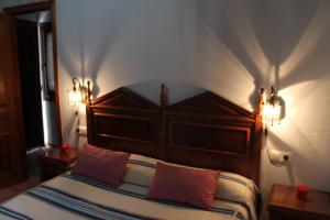 a bedroom with a bed with two red pillows at Suite Castillejo in Capileira