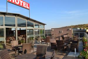 a patio with chairs and tables and a hotel at Alexander Hotel in Asenovgrad