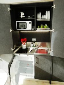 una pequeña cocina con fregadero y microondas en Bed & go Trento en Trento