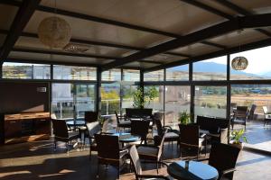 a dining room with tables and chairs and windows at Alexander Hotel in Asenovgrad