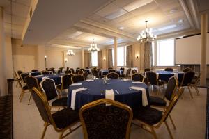 a conference room with tables and chairs and a screen at Prince Arthur Waterfront Hotel & Suites in Thunder Bay