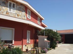 una casa rossa con finestre bianche e un vialetto di Casa da Pina a Càbras