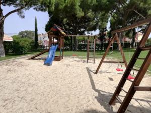 a playground with a slide in the sand at Apartamento Passarinhos in Albufeira