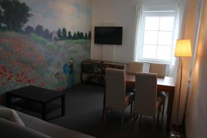 a dining room with a table and chairs and a television at Hotel Seepromenade in Meersburg