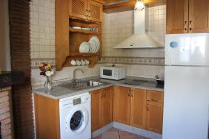 a kitchen with a washing machine and a refrigerator at La Tila in Capileira