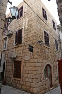 a stone building with windows and a sign on it at Hostel Korcula in Korčula