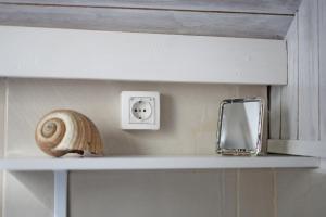 a shelf with a snail and a mirror on it at Hostel Korcula in Korčula