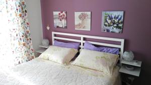 フォルミアにあるB&B Villa Noemiの紫の壁の白いベッドが備わるベッドルーム1室