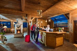 a man and woman standing at a bar in a cabin at Almdorf Sankt Johann in Sankt Johann im Pongau