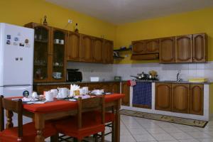 una cucina con tavolo e frigorifero bianco di La Casa del Gelso Fiorito a Eboli