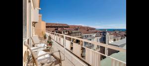 balkon z krzesłami i widokiem na miasto w obiekcie Appartamento via volta w San Remo