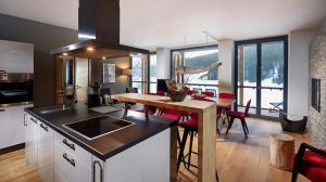 a kitchen and living room with a table and a dining room at Black Forest Lodge in Feldberg