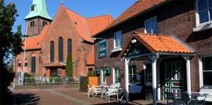 a building with tables and chairs and a church at Sohre in Hamburg