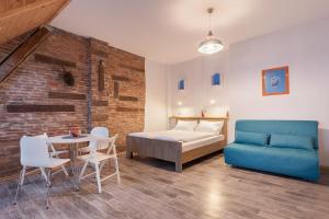 1 dormitorio con 1 cama, mesa y sillas en 7 Apartments en Leópolis