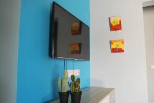 ein Spiegel an einer Wand neben einem Tisch mit einem Kaktus in der Unterkunft Villa Un Jour, Un Rêve in Chassaing