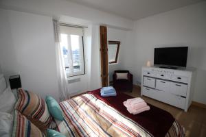 a bedroom with a bed and a flat screen tv at Appartements à Deauville dans Triangle d'Or in Deauville +19 photos