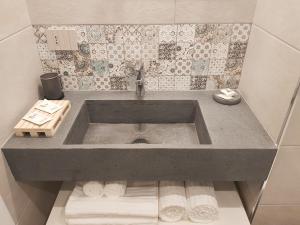 a sink in a bathroom with towels under it at VENTIMIGLIA SUITE & WINE in Catania