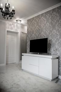 una sala de estar con TV en un armario blanco en Glamour Apartments en Piła