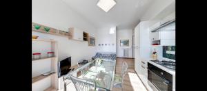 uma cozinha com uma mesa de vidro e cadeiras em Appartamento via volta em Sanremo