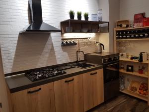 a kitchen with a sink and a stove top oven at VENTIMIGLIA SUITE & WINE in Catania