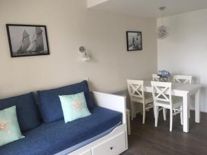 a living room with a blue couch and a table at Appartements Duplex de Charme à Bénodet Vue Mer in Bénodet