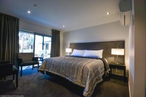 a hotel room with a bed and a large window at Carnmore Chateau Marlborough in Blenheim