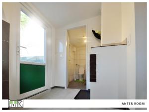 クラーゲンフルトにあるACO Living - A Cheap Overnightの緑のドアとバスルームが備わる客室です。