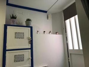 een kamer met een koelkast en een deur met potplanten bij Casa da Mariquinhas in Lissabon
