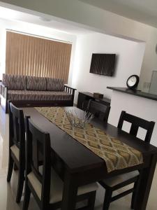 ein Esszimmer mit einem Tisch und einem Sofa in der Unterkunft Apartamento El Maiten in San Carlos de Bariloche