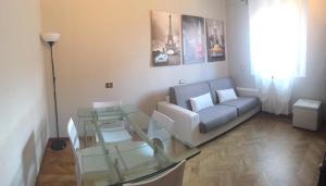 a living room with a couch and a glass table at Casa Casò Guest House in Bologna