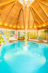 a large swimming pool with a wooden roof at Kinderhotel Appelhof in Mürzsteg