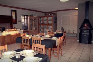 a dining room with a table and chairs and a stove at Aqua Terra Guest House in Lydenburg