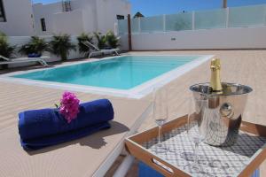 a pool with a table with a bottle of champagne and glasses at Villa Princesa Sofia in Puerto del Carmen