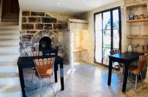 a dining room with a table and chairs and a fireplace at Mas Guiraud, le Coquet in Beaucaire