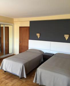 ein Schlafzimmer mit 2 Betten und einer schwarzen Wand in der Unterkunft Hotel Nuevo Cachalote in Portonovo
