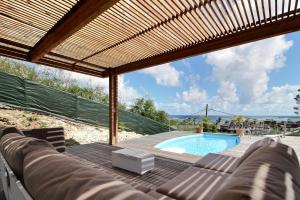 a patio with a couch and a swimming pool at Villa Thomana, piscine, vue mer et plage à 100 m ! in Le Moule
