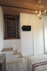 um quarto com uma cama e uma televisão na parede em Casa Del Principe em Gambassi Terme
