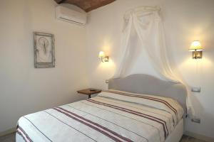 a white bedroom with a bed with a canopy at Casa Del Principe in Gambassi Terme