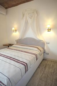 um quarto com uma cama de dossel branco em Casa Del Principe em Gambassi Terme