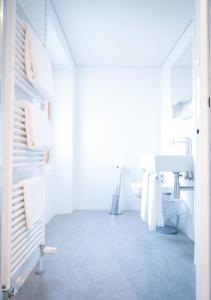 La salle de bains blanche est pourvue d'un lavabo et d'un miroir. dans l'établissement Bed&Bike Tremola San Gottardo, à Airolo