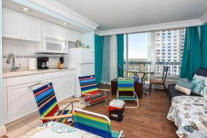 a kitchen with colorful chairs in a room with at Ocean view studio condo. in Daytona Beach