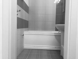 a white bathroom with a tub and a sink at Faleza Apartment in Galaţi +24 photos
