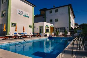 a swimming pool in front of a hotel with tables and chairs at Apart Sabina del Mar in Mar de Ajó