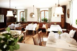 a restaurant with white tables and chairs and windows at Hotel Burgmeier in Dachau