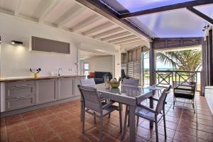 a kitchen and dining room with a table and chairs at Appartement THOMANA , jacuzzi privé, plage à 200 m in Le Moule